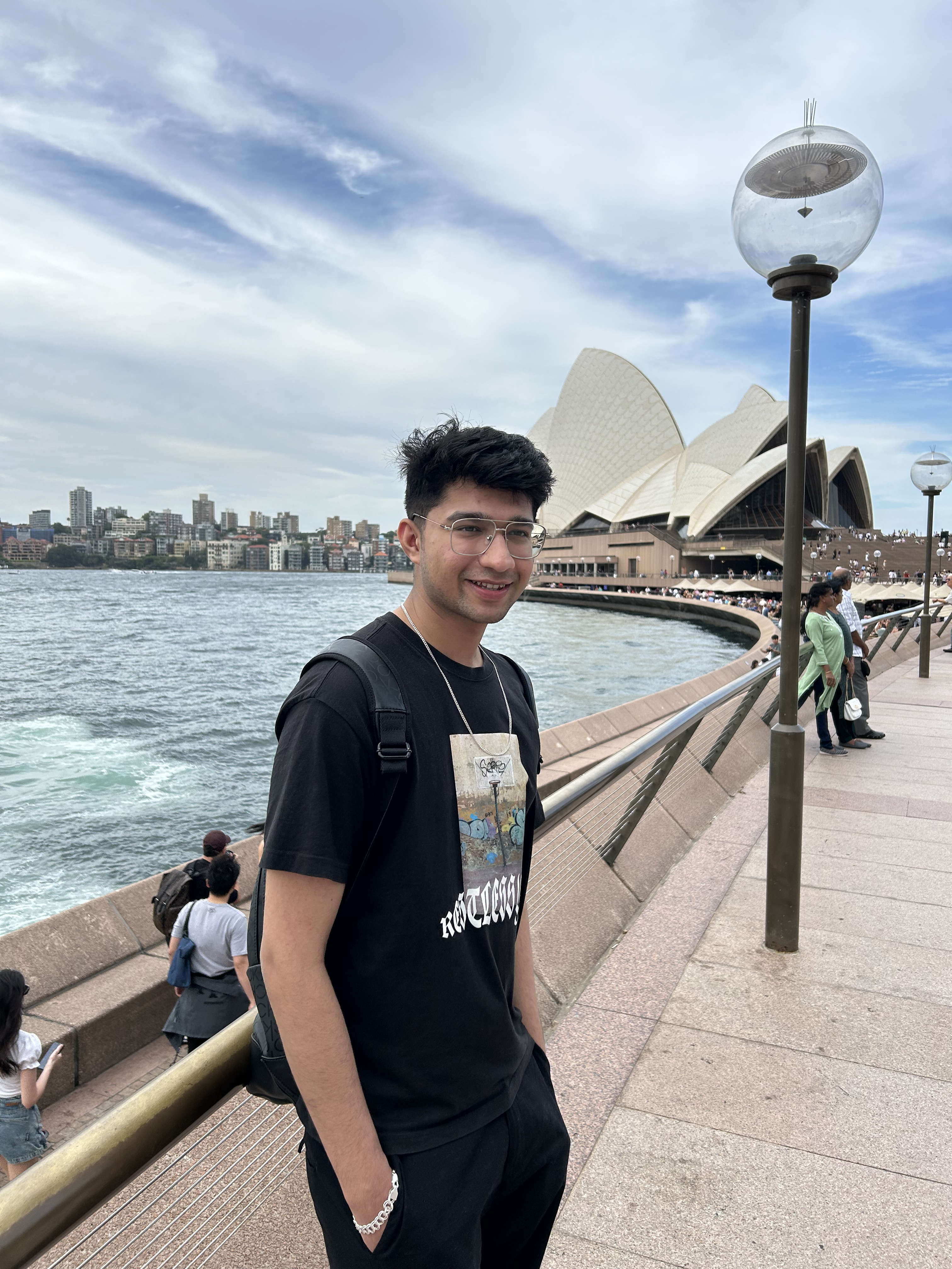Naman on the Sydney harbour walkway with the Opera House behind him on his first day in the city